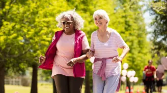 Two elderly women walking in the park.