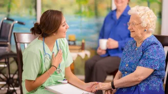 Nurse talking to mother and daughter.