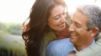 A woman hugging her husband while enjoying a walk outdoors.