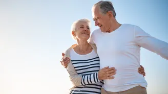 A couple walks on the beach after a successful hernia surgery.