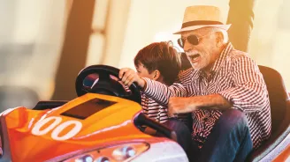 Grandfather and grandson playing in a bumper car