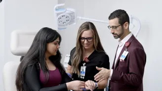 Two medical providers talking with a patient.