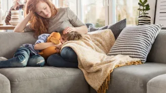 Sick child with mom on couch.
