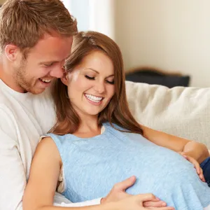 preganant couple sitting on couch