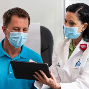 A female physician showing her patient something on the tablet