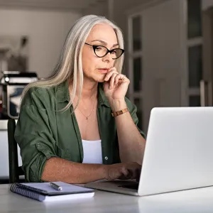 A woman in her office and on the laptop