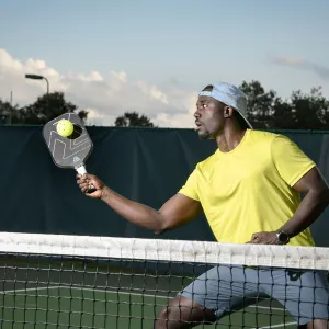 A Man Playing Pickleball on a Tennis Court