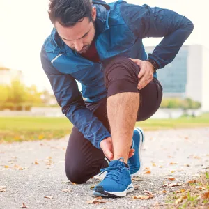 A Jogger Rubs His Ankle While Taking a Break