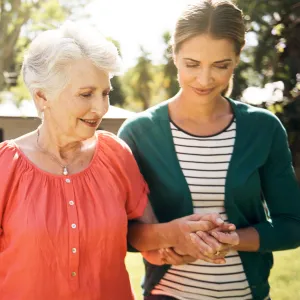 A mother and daughter, walking outside, offer emotional support to each other.