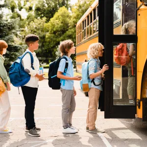 Children waiting to get on the school bus. 