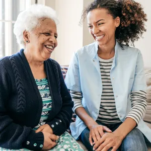 A caregiver laughs with their loved one.