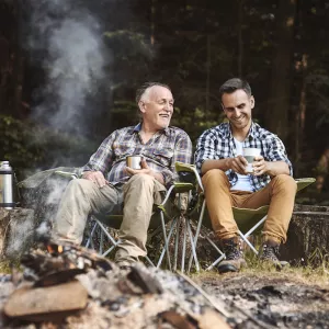 Two men sit in front of a fire and talk about their health