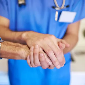 Nurse holding patient's hand