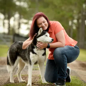 Woman petting her dog while outdoors.