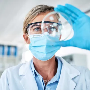 A medical researcher examining a medical petri dish