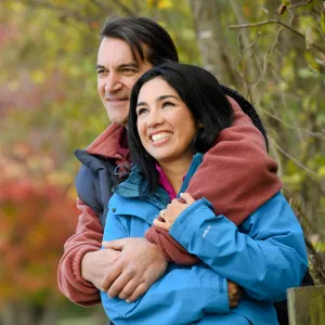Couple embracing in the woods.
