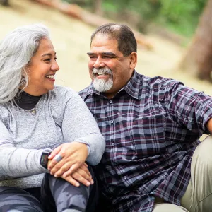 A Hispanic couple sitting at the park