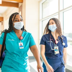 Two nurses walking in a hallway