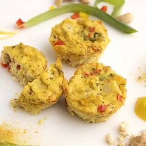 Three eggless frittatas on white surface with green onion garnish