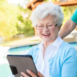 Elderly woman reading from a tablet