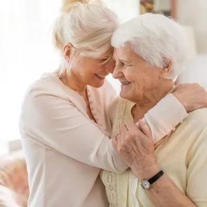 Two senior women hugging each other.