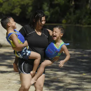 Mother playing with her two sons on the shore.