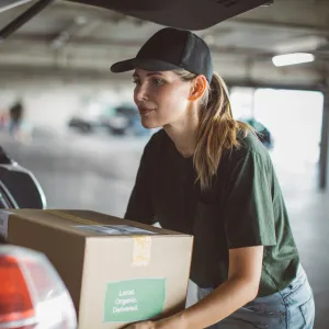 Woman loading car with box of food