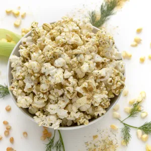 White bowl of seasoned popcorn on white counter