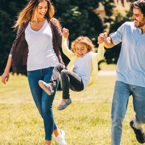 Family playing outside together in a park.