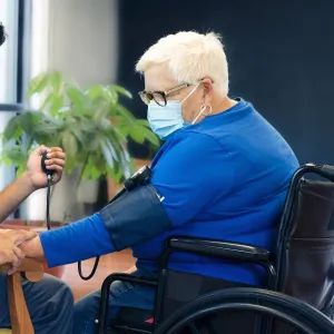 A health care professional checks a woman's blood pressure.