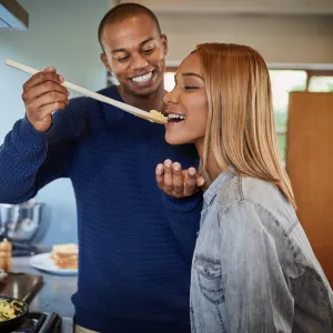 A couple taste tests their meal before eating.