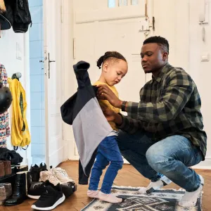 Father and daughter getting ready to go outside from their house