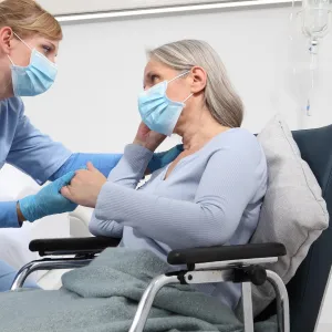 A caregiver comforts a patient. 