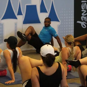 A group of runnings foam rolling with an AdventHealth expert at a runDisney race. 