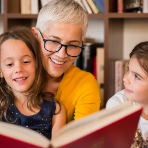 A grandmother reading to her granddaughters. 