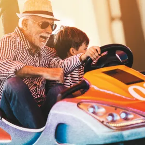 Grandfather and grandson playing in a bumper car