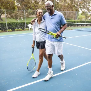 A happy couple plays a game of tennis.