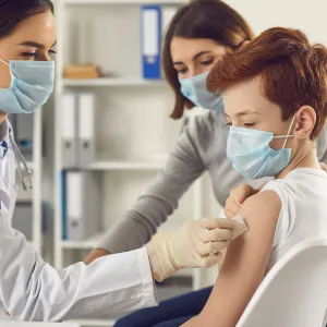 A young boy getting ready to receive a vaccine shot