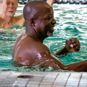 A man takes a water aerobics class.