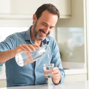 A man pouring a glass of water.