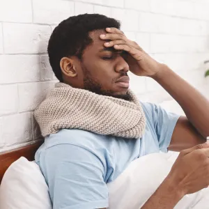 A man feeling under the weather in bed.