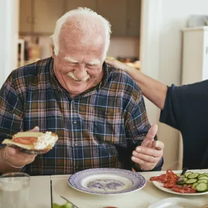 A couple enjoys a meal while laughing about their day.