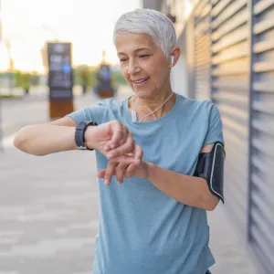 A woman checking her heart rate on a run.