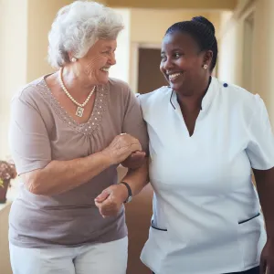 A woman walks with her nurse for treatment during an appointment.