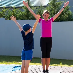 A mom does PE at home with her kids.