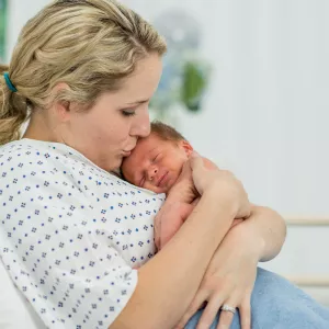 A mother holds her new baby in the hospital.