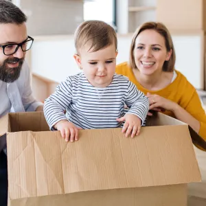 A baby playing in a cardboard box.