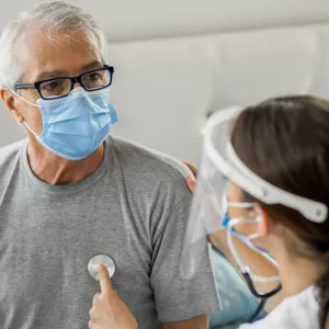 A doctor using a stethoscope on a patient