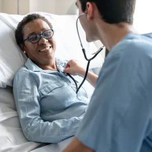 A patient in a hospital bed has her heart checked.