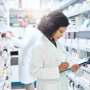 Female and male pharmacist working in an aisle in a pharmacy.